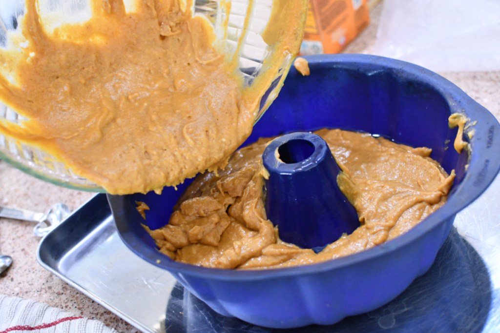 pouring batter into a bundt cake pan