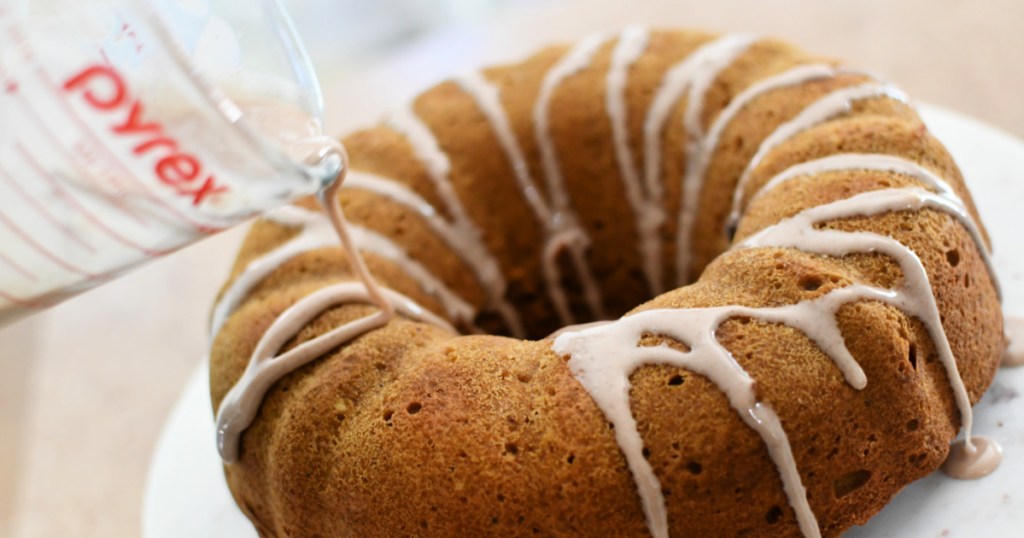 pouring cinnamon glaze over cake