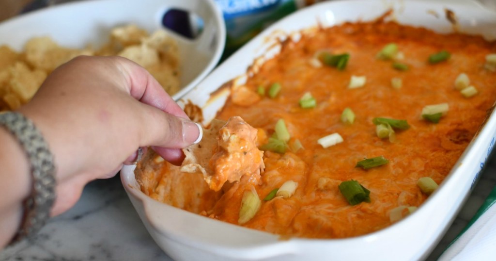 dipping chip into Frank's buffalo chicken dip 