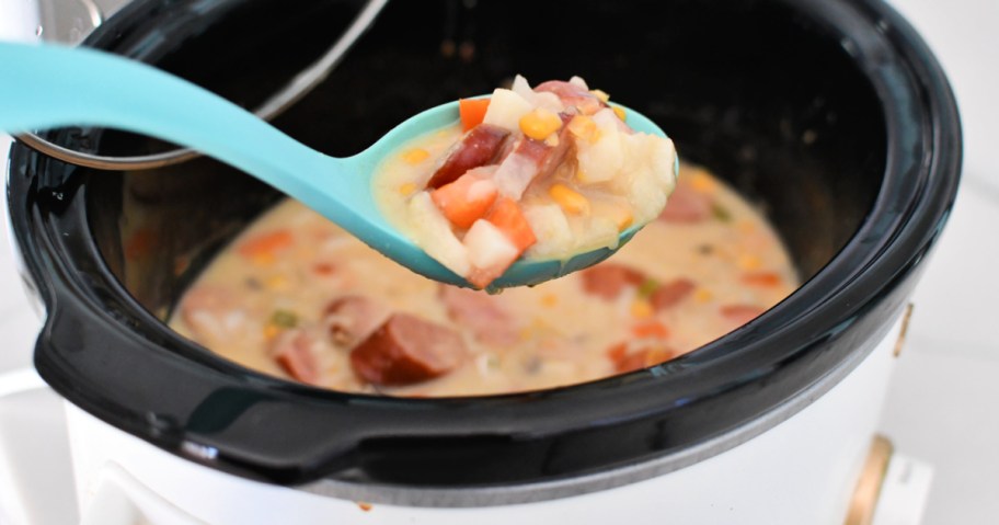 A slow cooker with sausage and corn chowder.