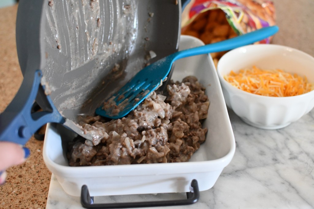 adding ground beef mixture to casserole dish