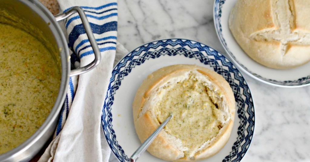 pot of broccoli cheddar soup next to bread bowl