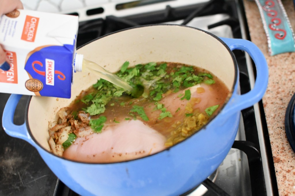 adding chicken broth to soup