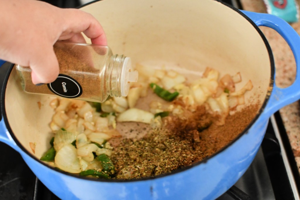 adding spices to chili