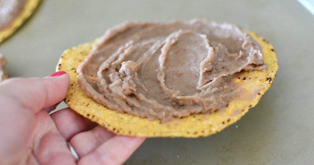 refried beans spread on tostada shell