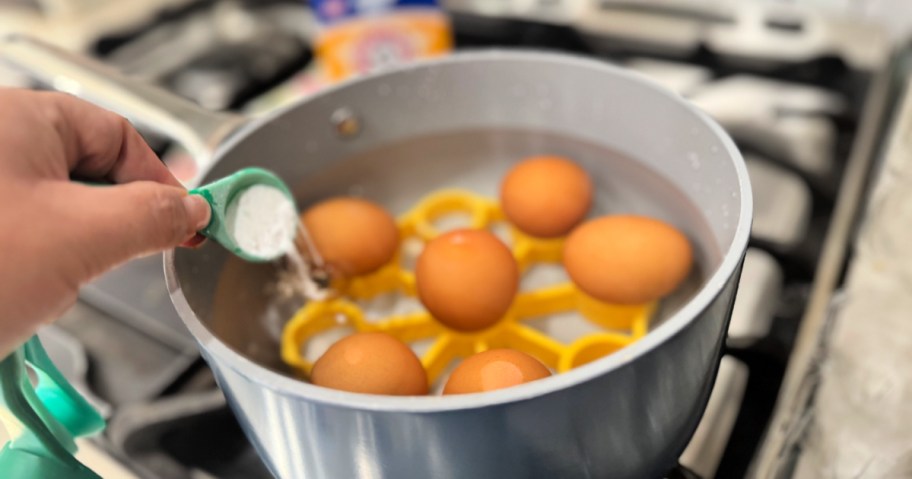 adding baking soda to eggs in a pot on the stove 