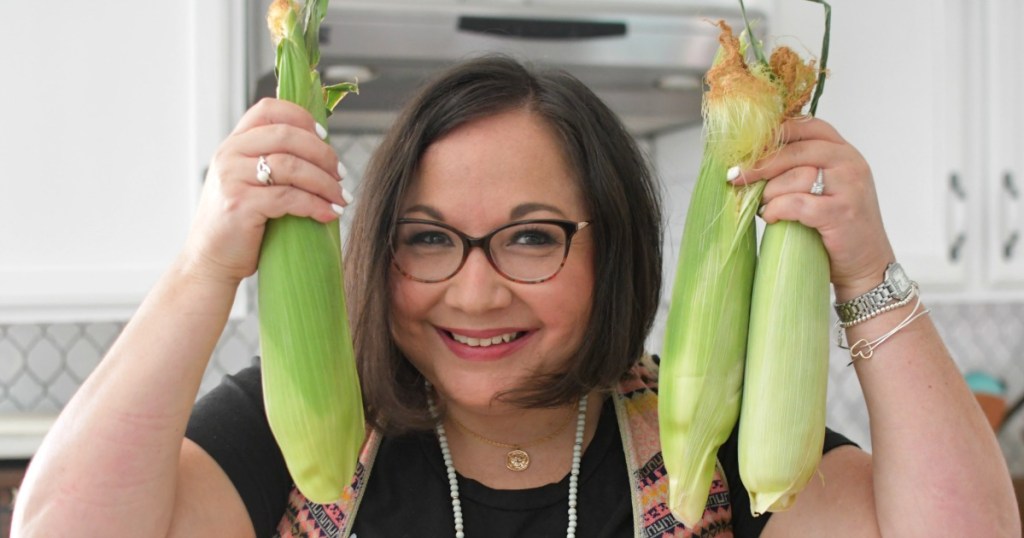 woman holding fresh corn on the cob
