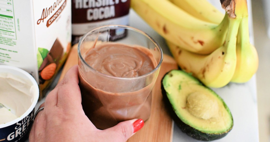 holding a fresh avocado chocolate smoothie