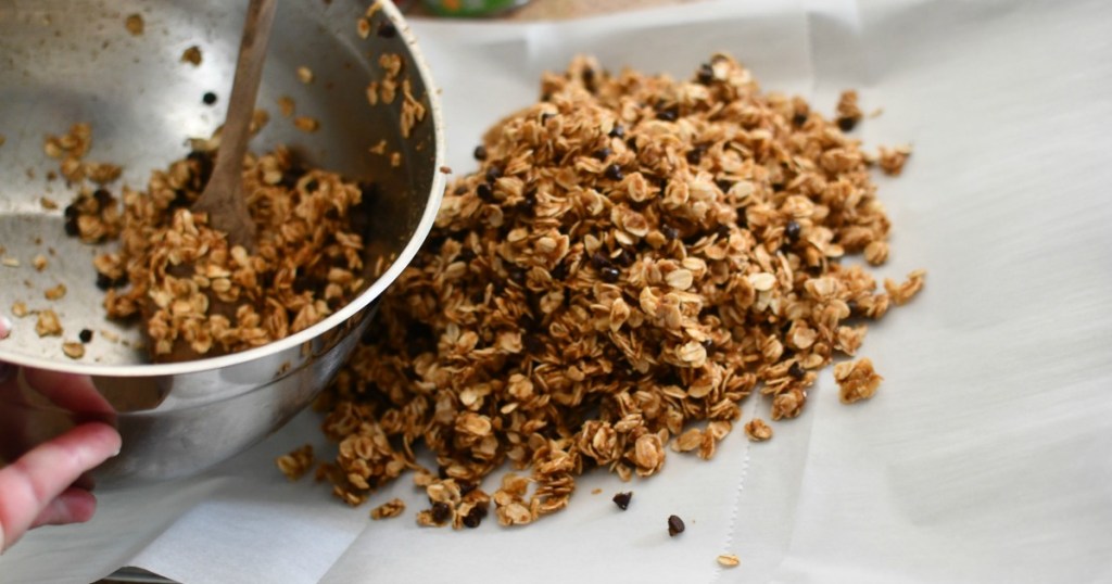 pouring granola bars onto a sheet pan