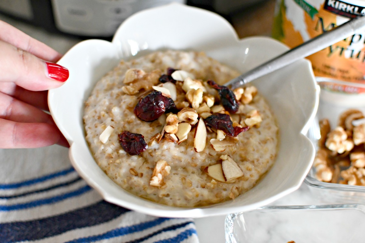 holding a bowl of steel cut slow cooker oatmeal