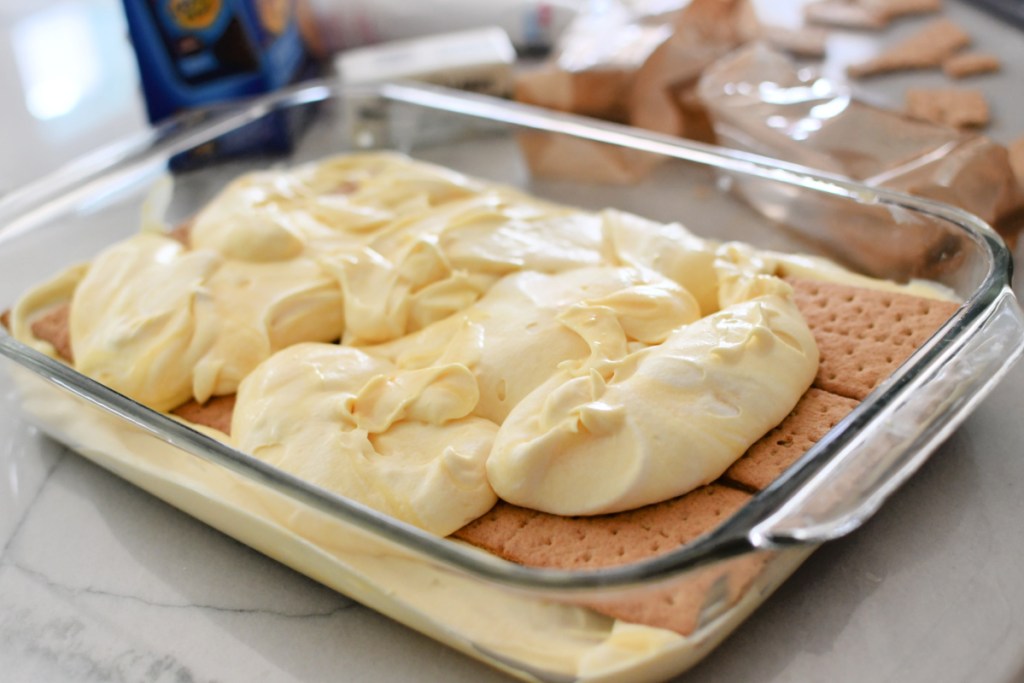 adding pudding and cool whip to eclair cake