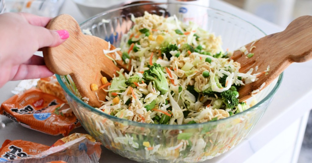 mixing ramen noodle salad with the dressing