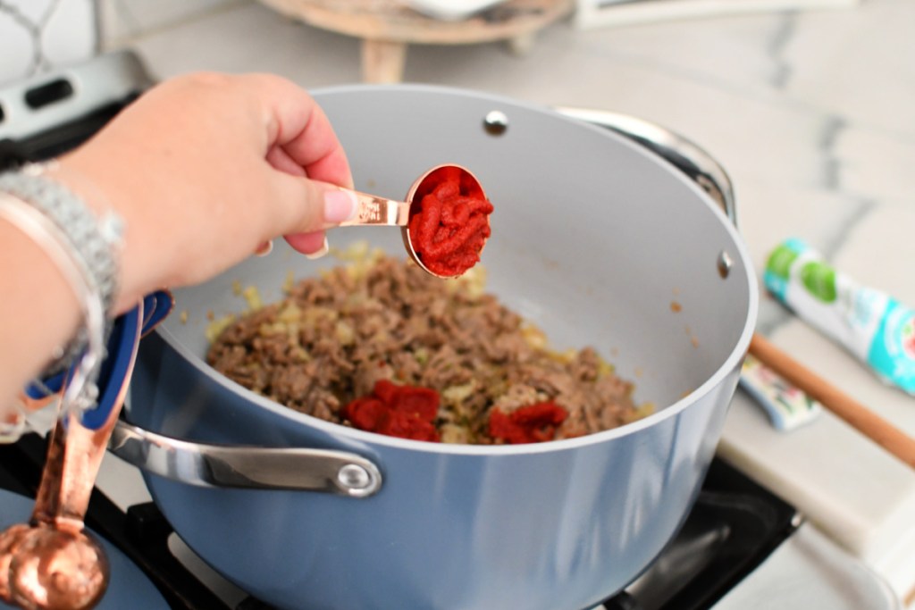 adding tomato paste to lasagna soup