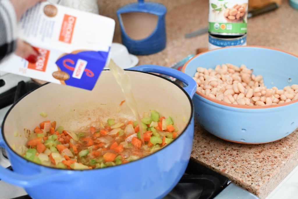 adding broth to soup