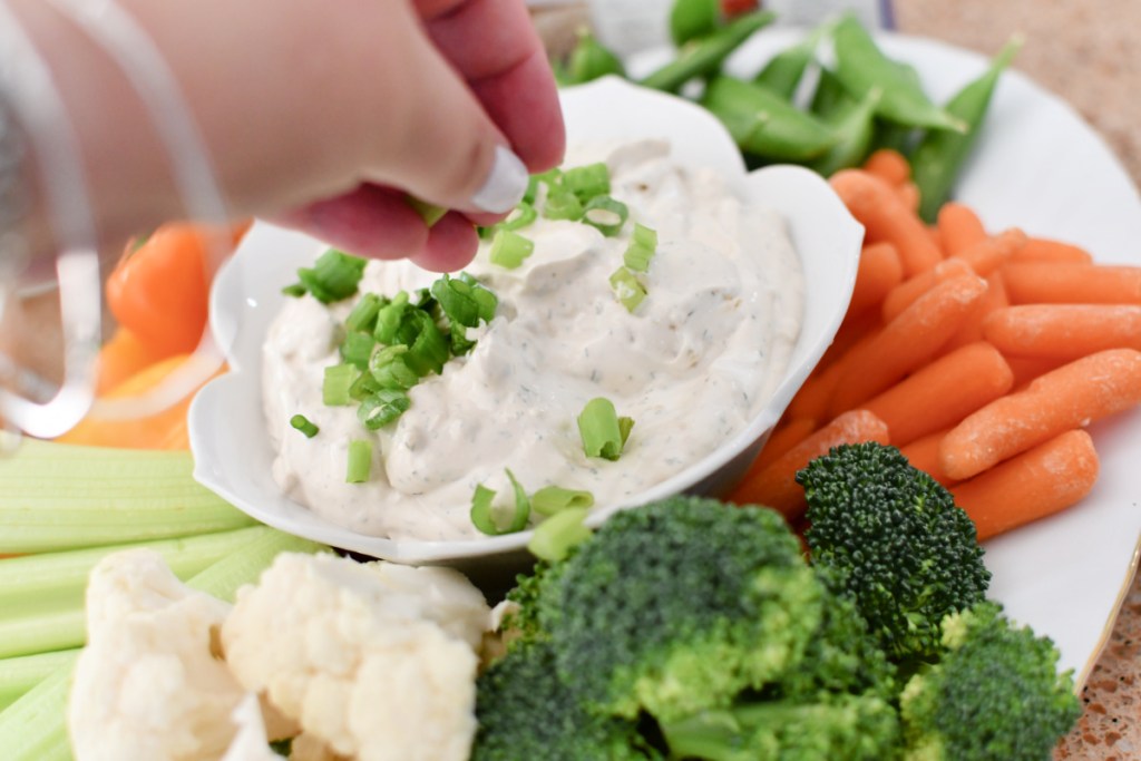 adding green onion to dip