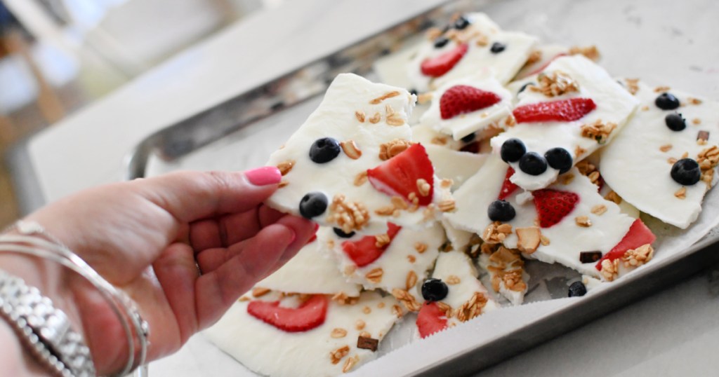 holding a piece of frozen yogurt bark