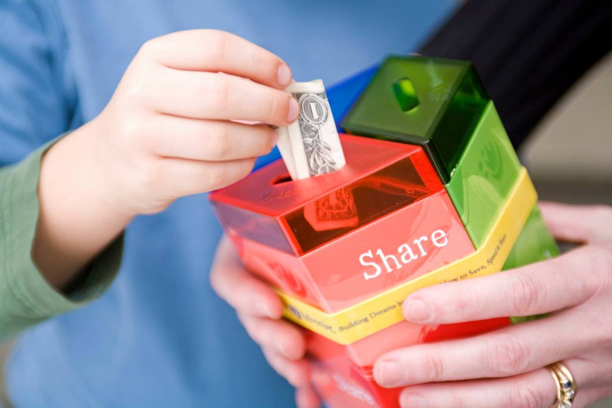 child putting money in MoonJar savings kit