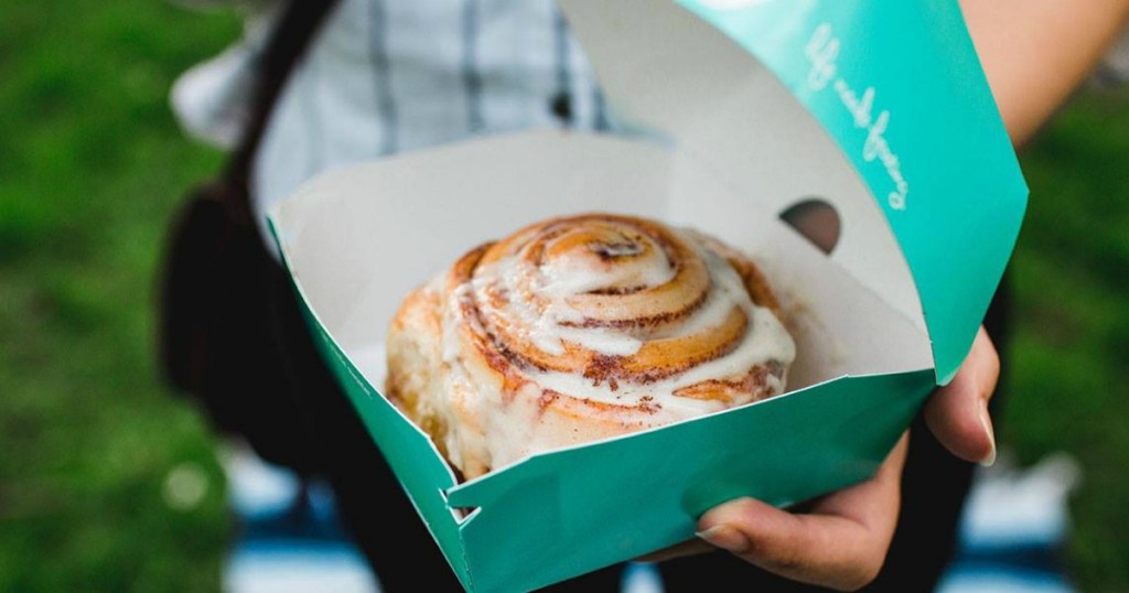 Cinnabon treat in persons hand 