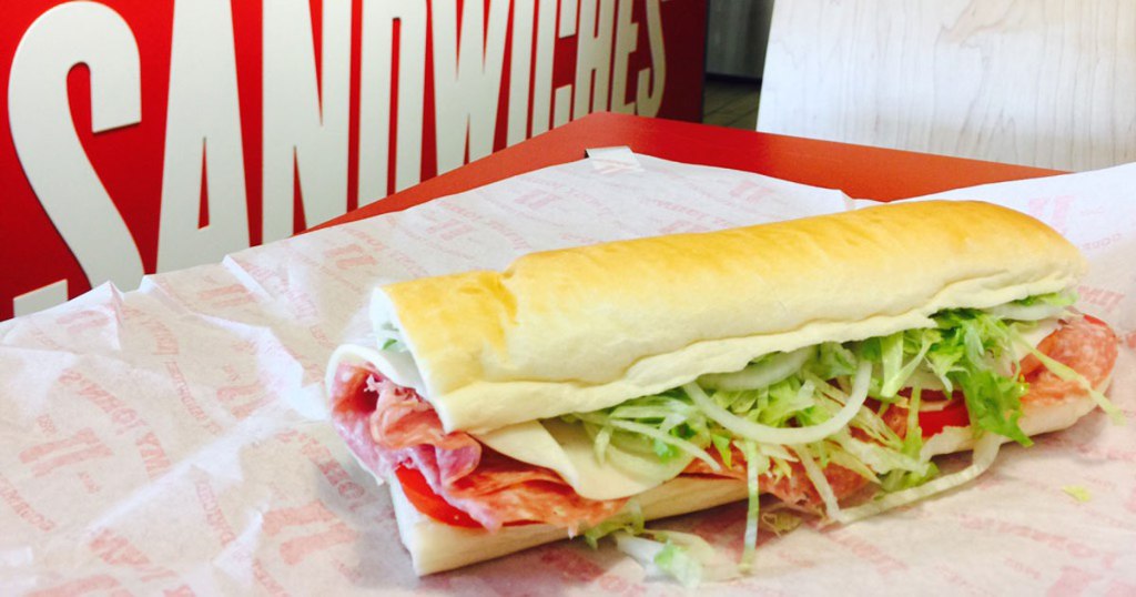 sub sandwich laying on a wrapper on a restaurant table