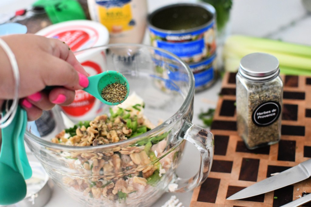 adding herbs to chicken salad