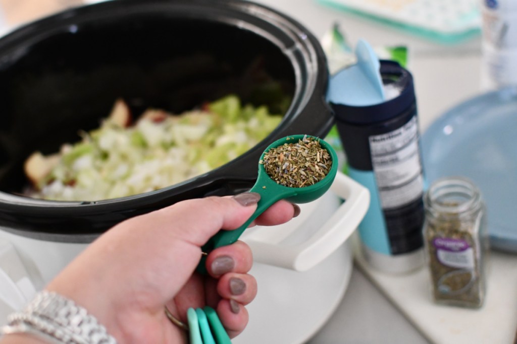 adding seasoning to pot pie soup in slow cooker