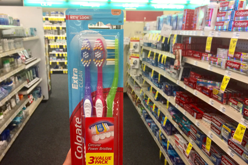 hand holding Colgate toothbrush multipack