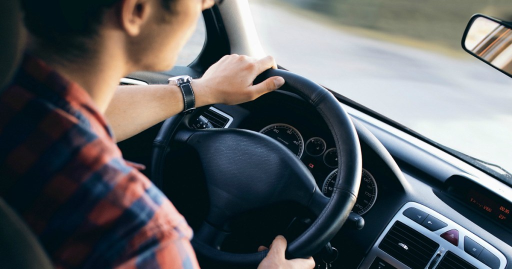 looking over the shoulder of a man driving a car