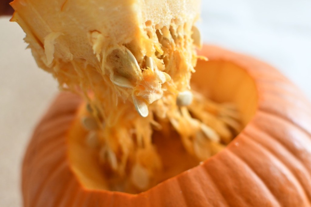 lifting top of pumpkin to reveal inside