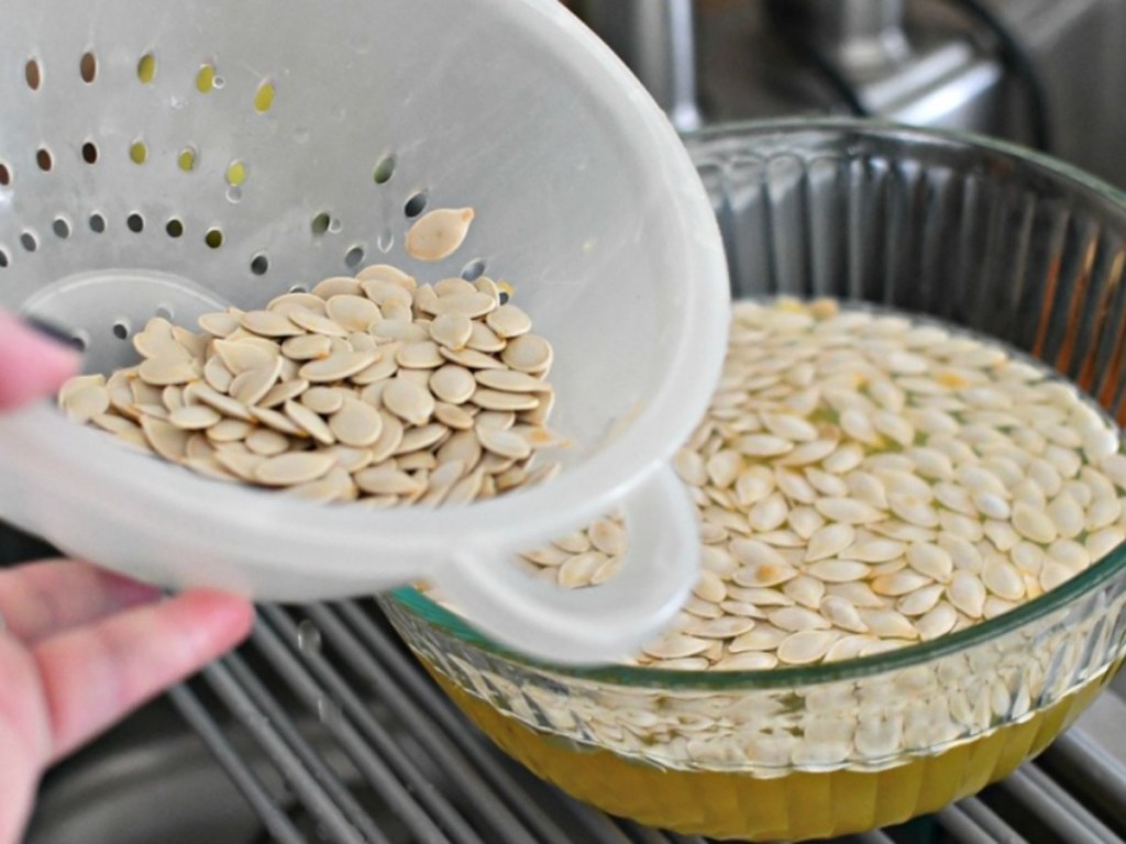 pumpkin seeds in colander and bowl