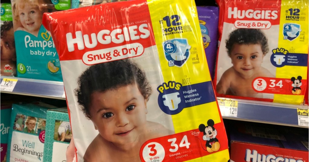 hand holding a package of Huggies diapers