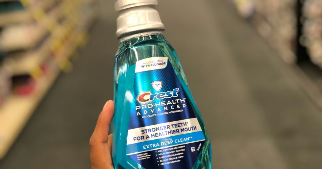 hand holding a bottle of Crest mouthwash