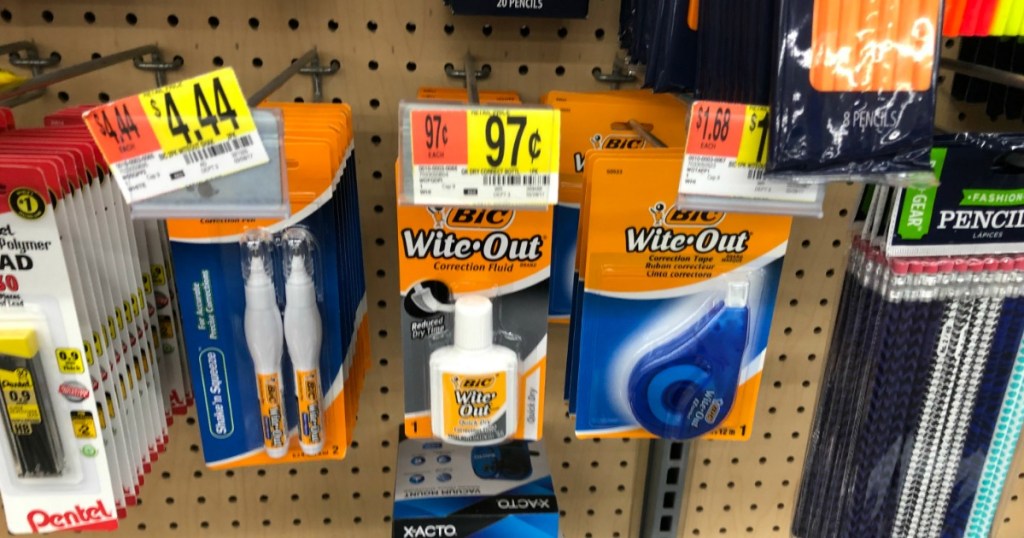 store shelf of office products hanging on peg board with white out packages hanging on the pegs