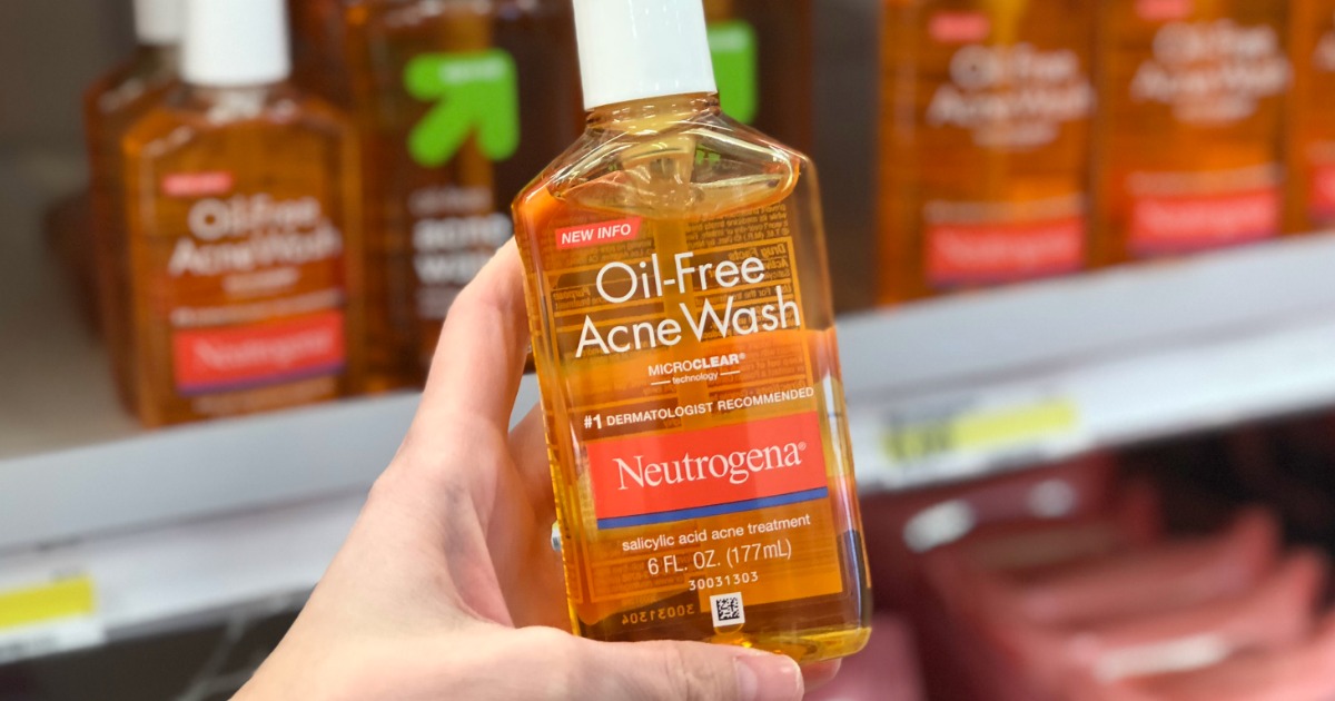 hand holding a bottle of neutrogena acne wash in front of a store shelf