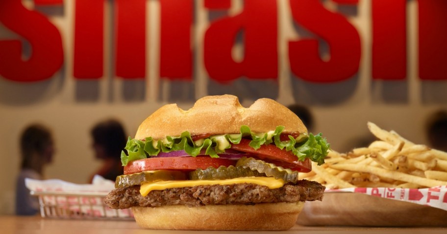 Smashburger cheeseburger with fries in basket on table