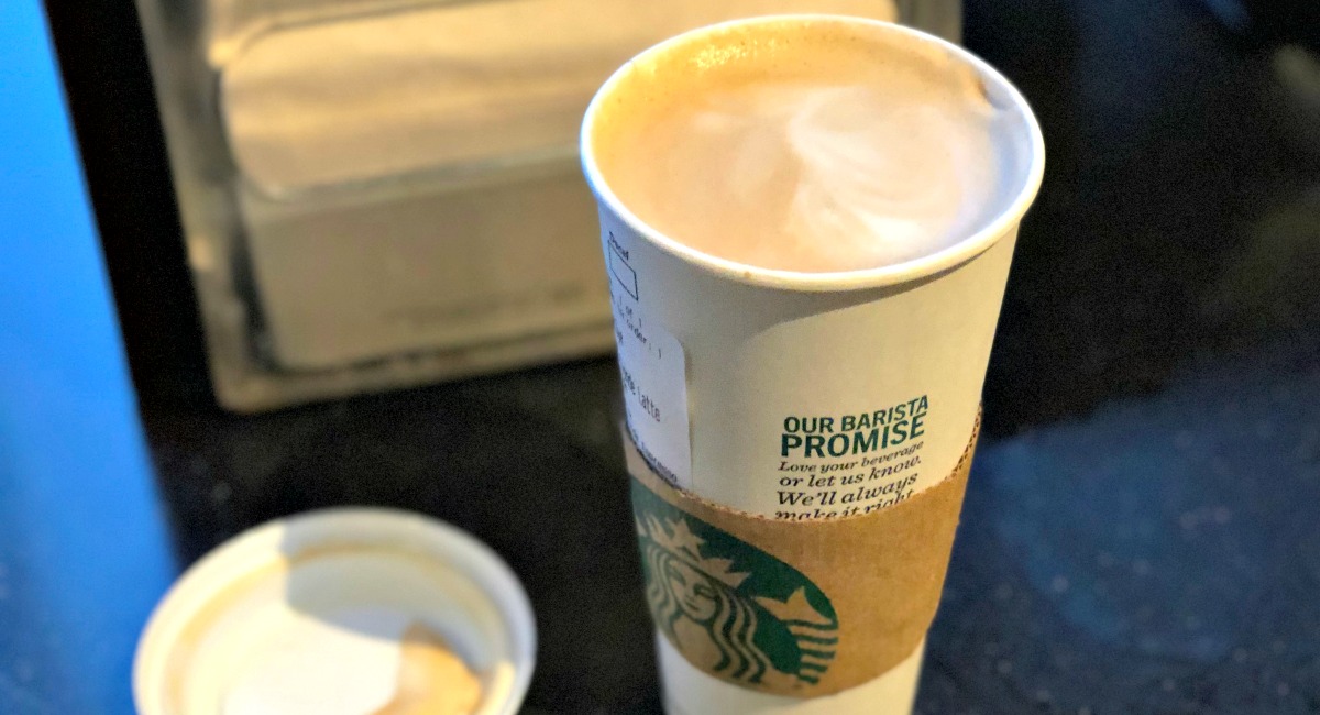 starbucks drink with the lid off resting next to the cup