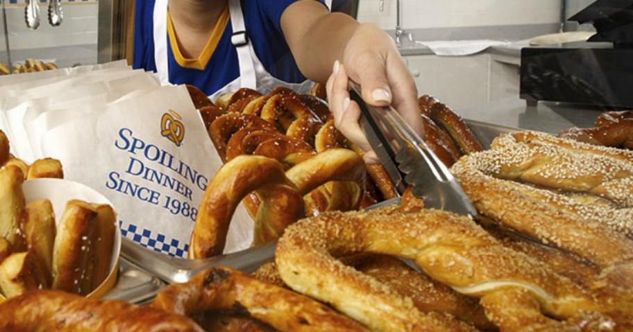 person using tongs to grab a pretzel