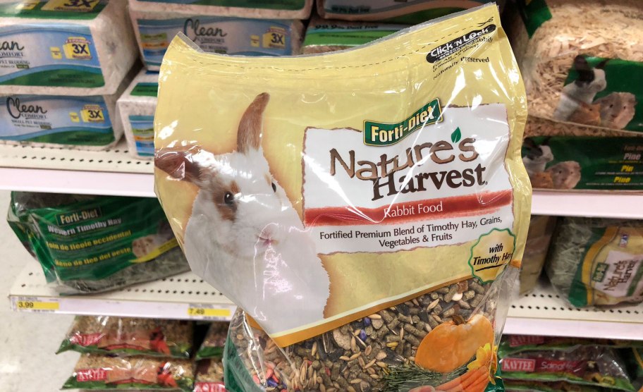 A person holding a bag of rabbit food