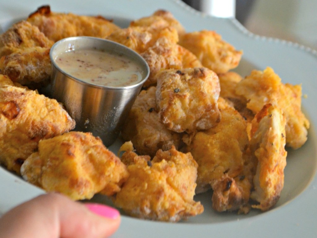 Woman holding plate of air fryer nuggets