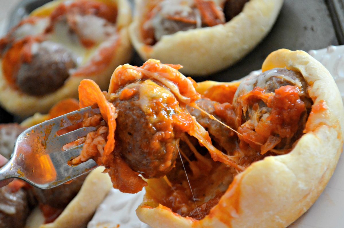 taking a fork full of filling out of a meatball pizza bowl