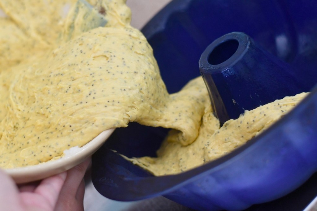 pouring sherry poppyseed cake into a bundt pan