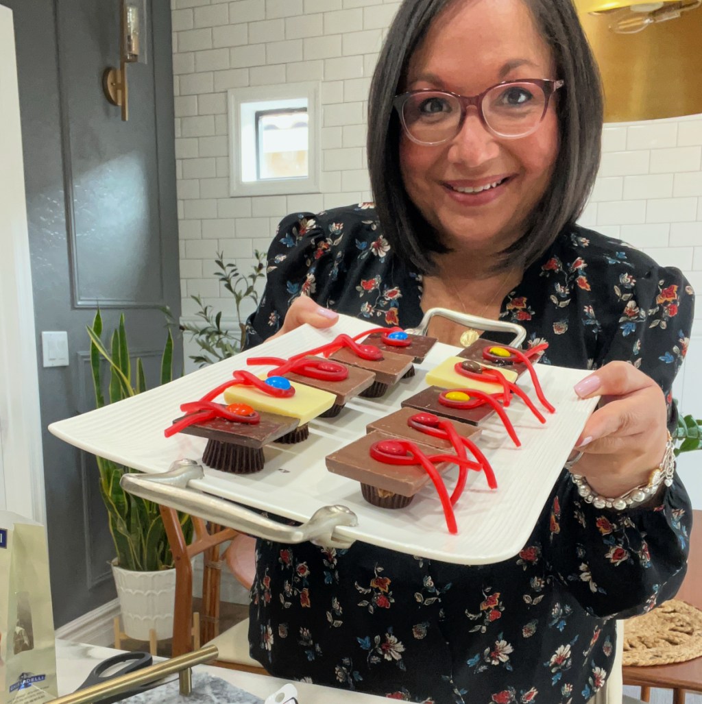 woman holding a tray of chocolate graduation treats