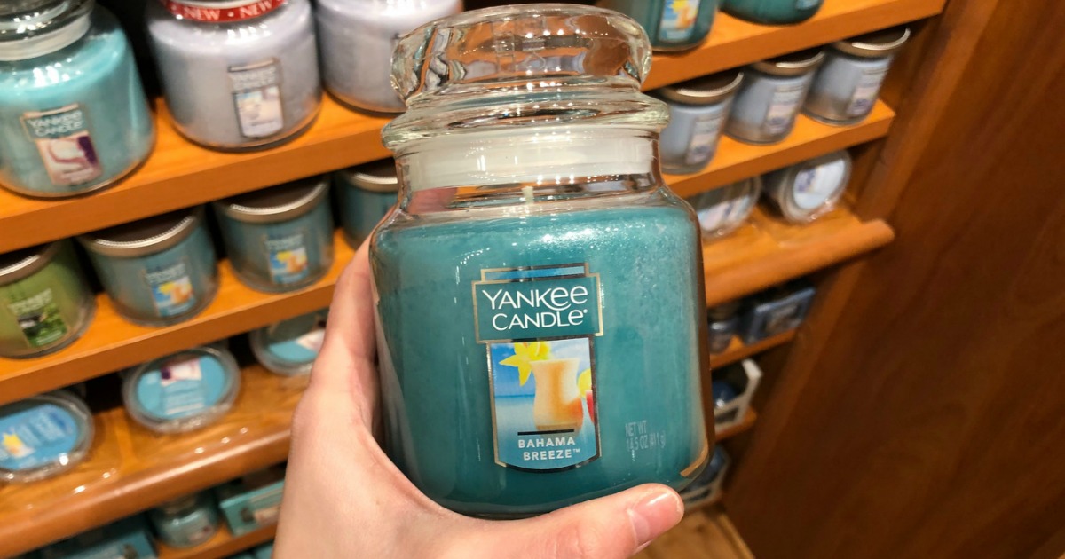 hand holding Yankee Candle jarred candle in-store