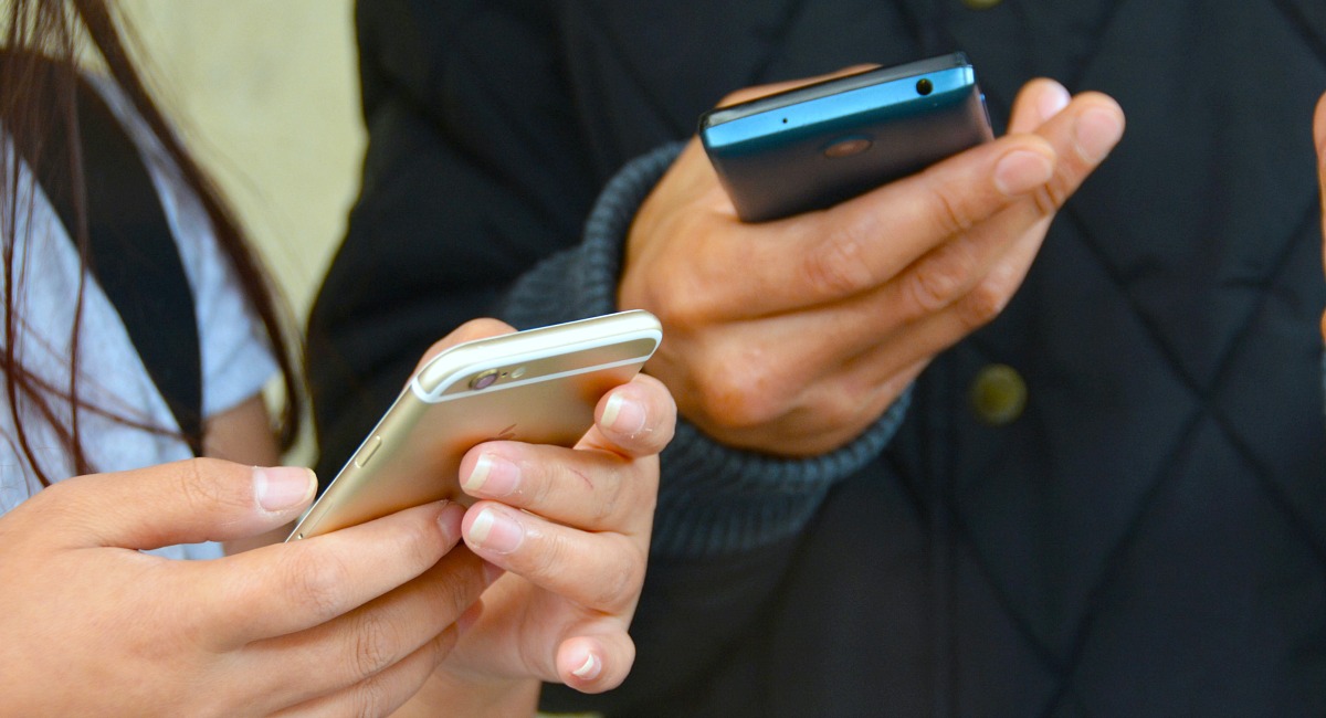 two people holding smartphones