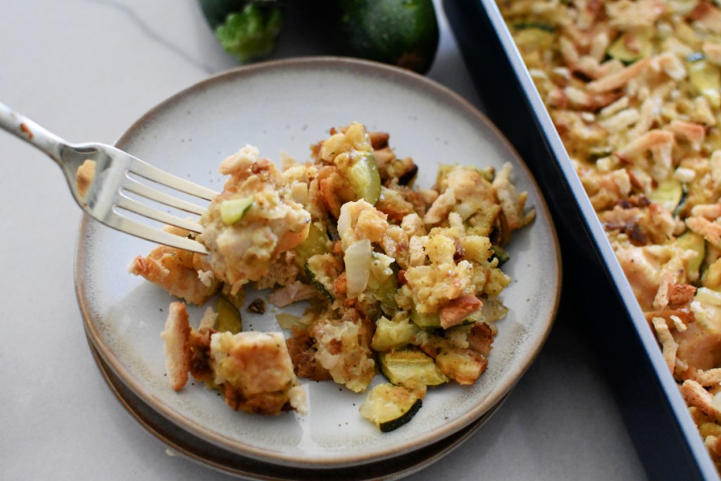 eating a plate of zucchini casserole with a fork