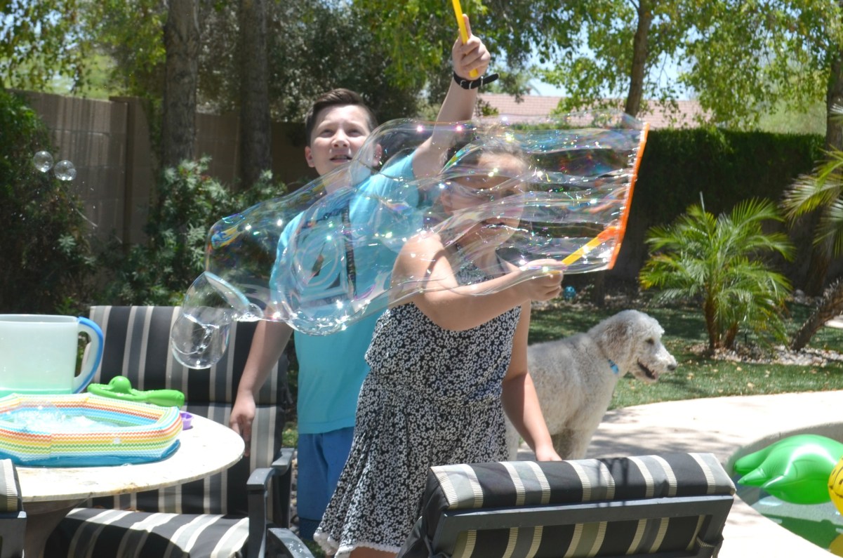 kids playing with giant bubbles outside