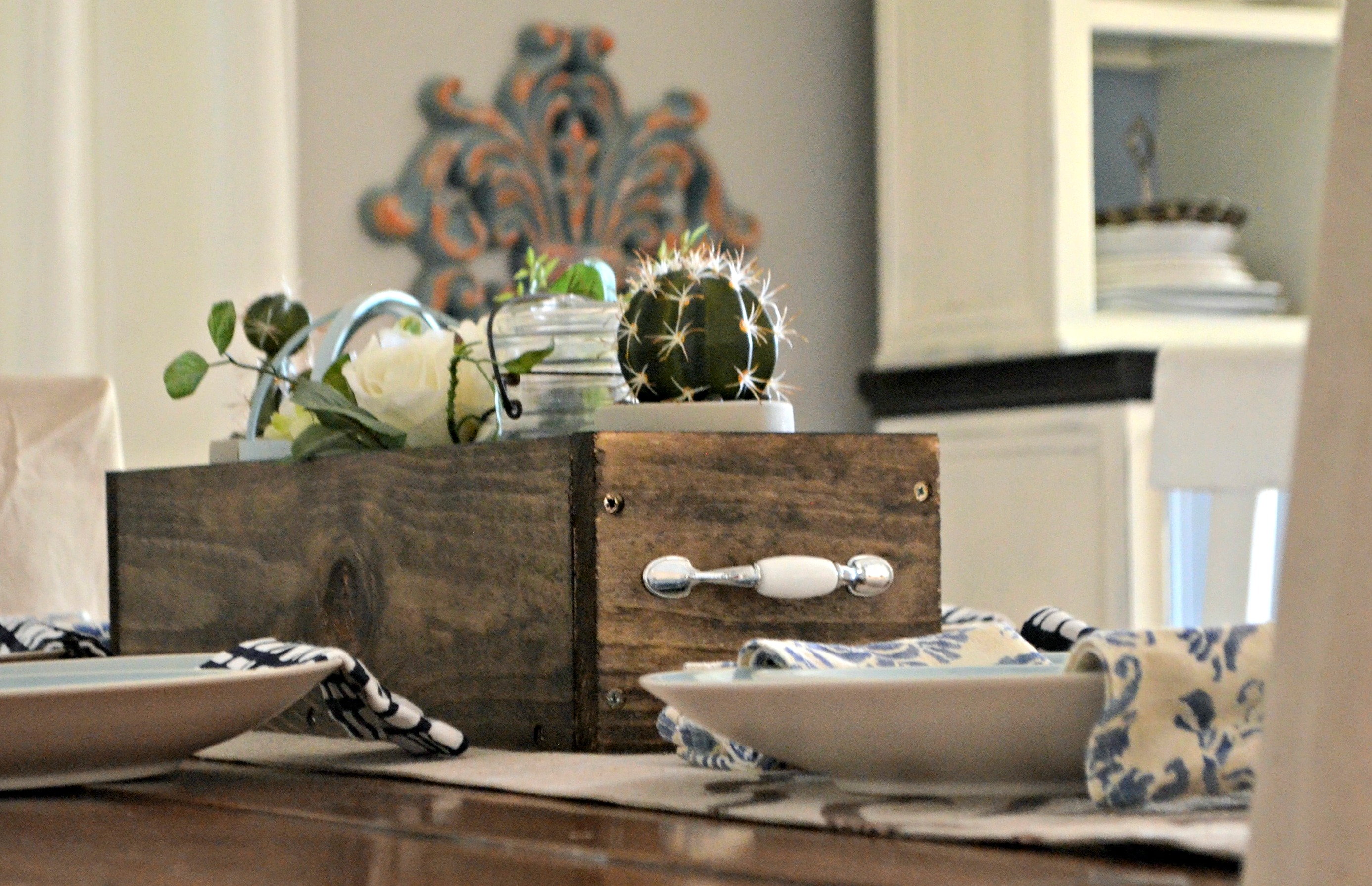 diy rustic farmhouse wood box centerpiece – filled with cute items like cacti, a vase, and a candle