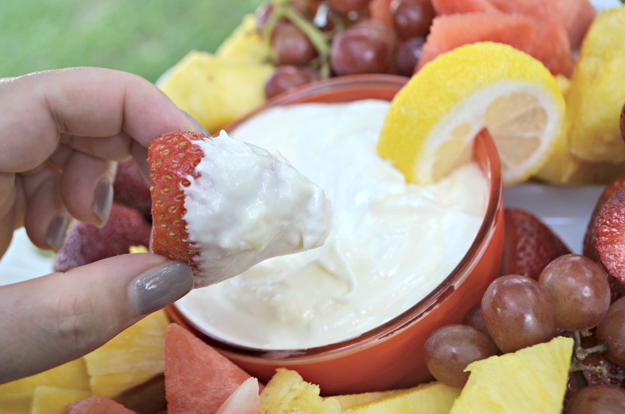 dipping a strawberry into the dip