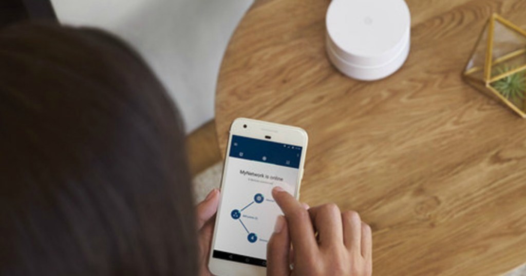 Woman using Google WiFi router on her phone at table