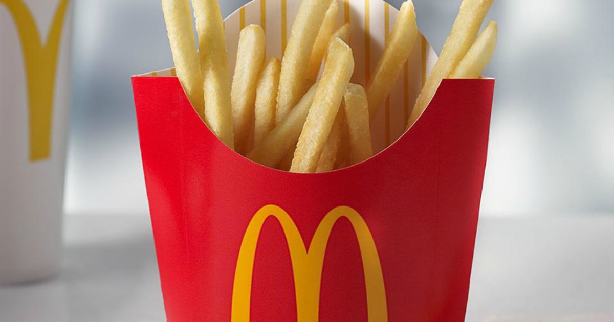 McDonald's Fries on a table with McDonald's cup in background