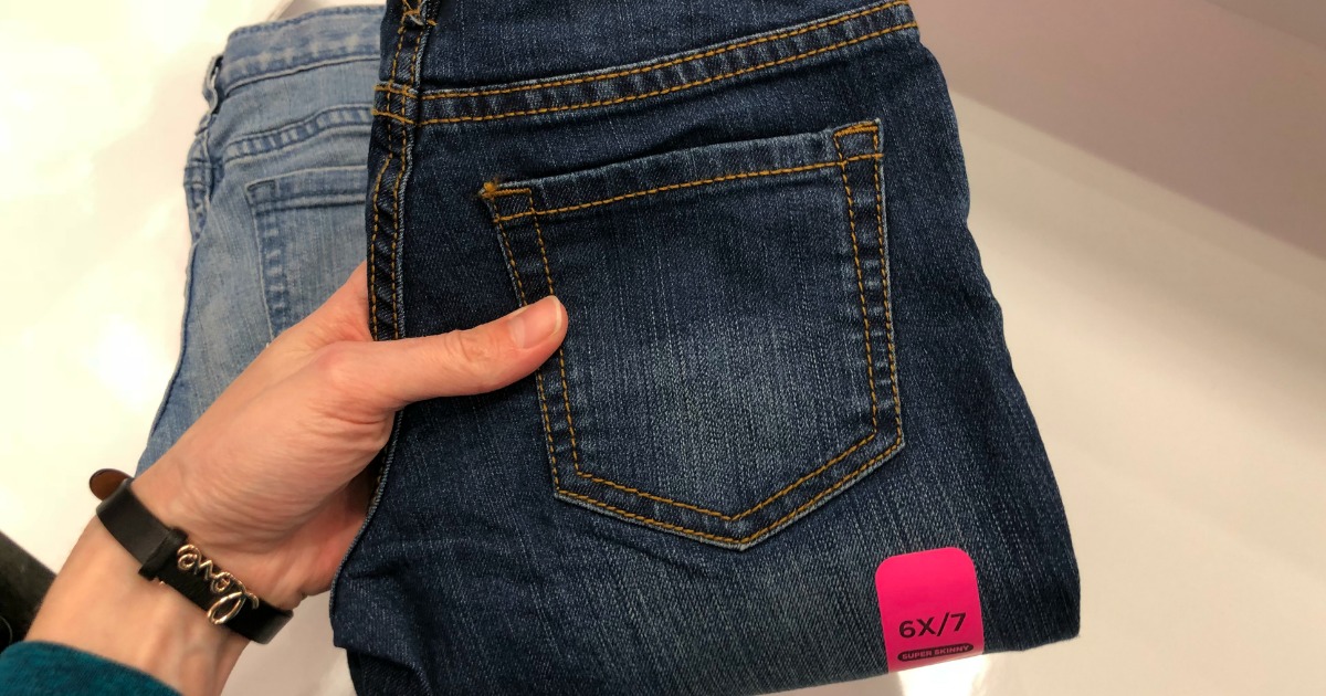 Dark denim pants held up to display